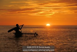 Boys paddling their pirogue into the sunset, Baramahamay Estuary